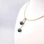 Collier 'mango' sur câble 40cm en or jaune 18 carats dévissable, 2 perles de Tahiti cat. 'top gem', ronde 9.1mm aubergine / ovale 9mm vert