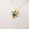 Pendentif 'tortue' en plaqué or et zircons, 1 perle de Tahiti ronde, catégorie B, 10mm, vert